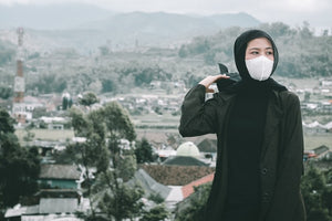 korean woman wearing a korean kf94 mask outside with mountain backdrop