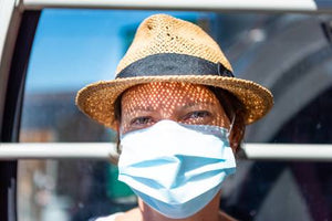 adult woman wearing surgical mask and a hat