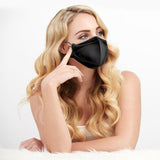 woman with blonde hair sitting wearing a black kf94 mask